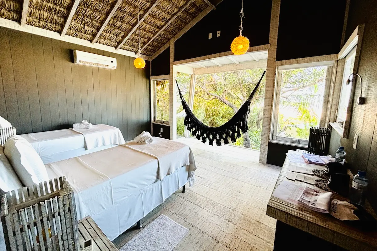 Cozy twin bedroom with hammock and tropical garden view at Kite Sisters Brazil kiteboarding retreat villa.