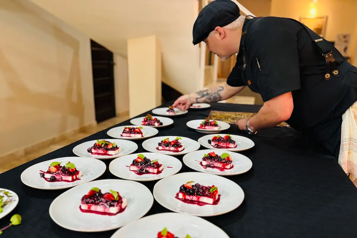 Kite Sisters head chef carefully plating berry desserts for guests at the Kitesurf retreat Belize.