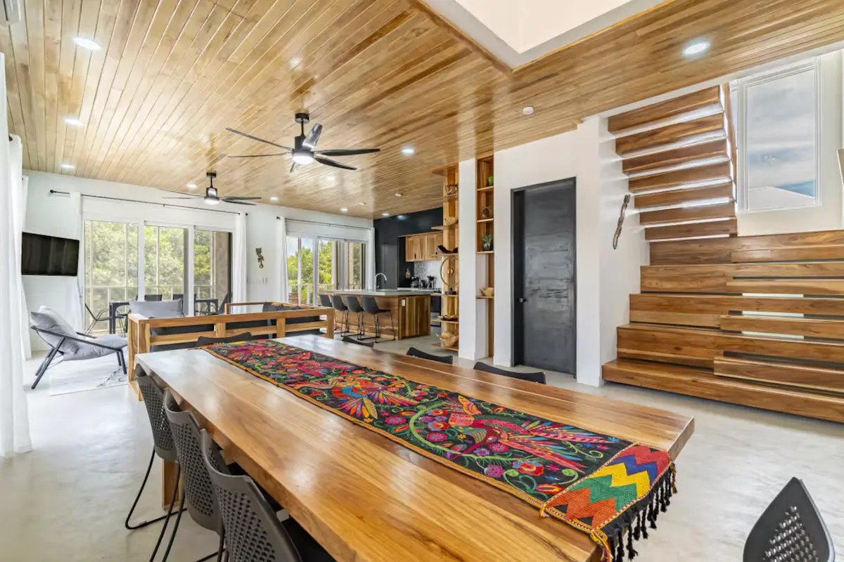 Luxury villa dining room with wooden ceiling and colorful table runner at Kite Sisters Belize kitesurf retreat.