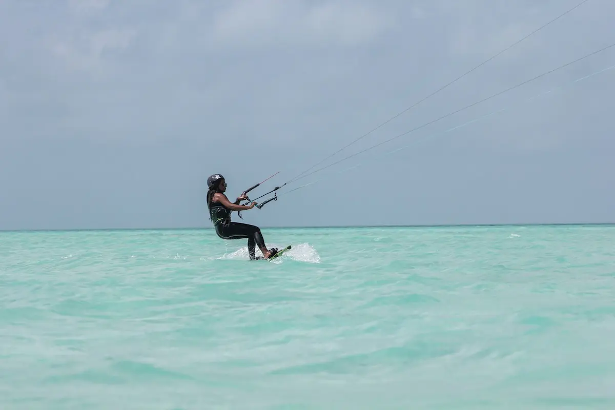 Kite Sisters woman kiteboarding on calm turquoise water at the Belize kitesurf retreat sandbar.