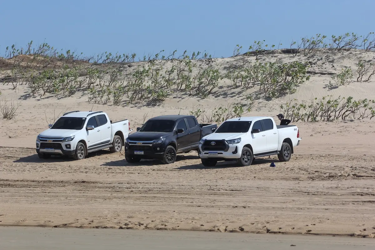 Kite Sisters Brazil kitesurf retreat 4x4 trucks parked on sand dunes ready for kite spot transfers.