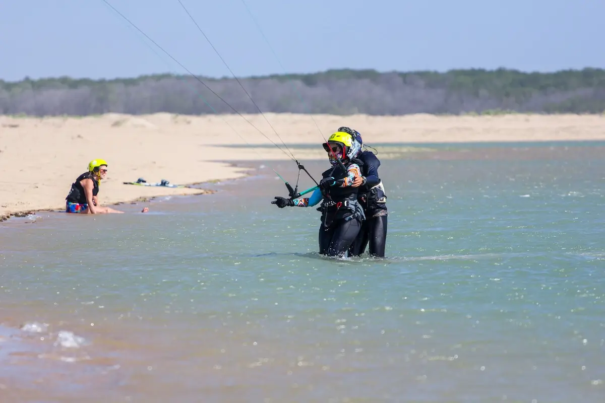 Kite Sisters certified instructor giving hands-on coaching to a student in the water at Brazil kitesurf retreat.