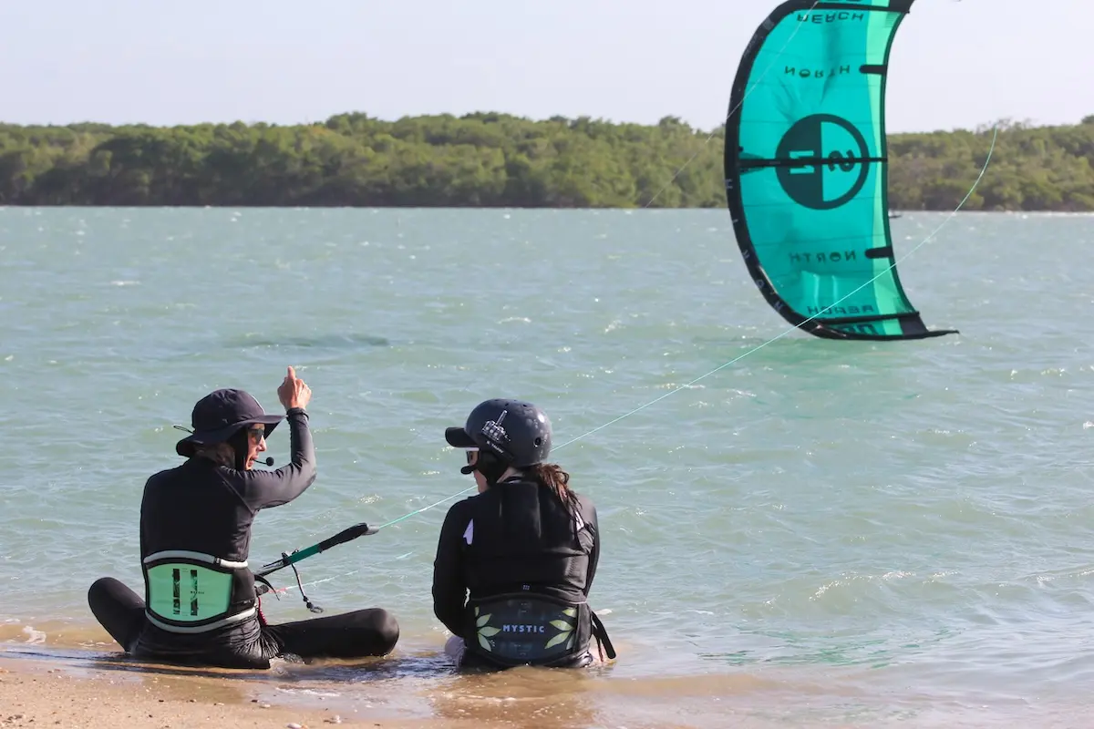 Kite Sisters certified instructor explaining to a student by the lagoon at Brazil kitesurf retreat.