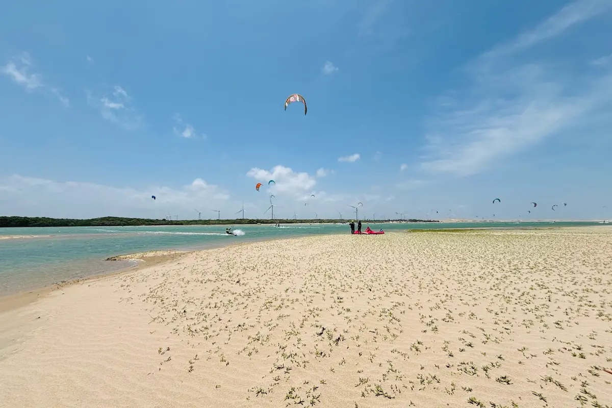 Panoramic view of Kite Sisters kitesurf retreat Brazil kite spot with sandbar lagoon and wind turbines.