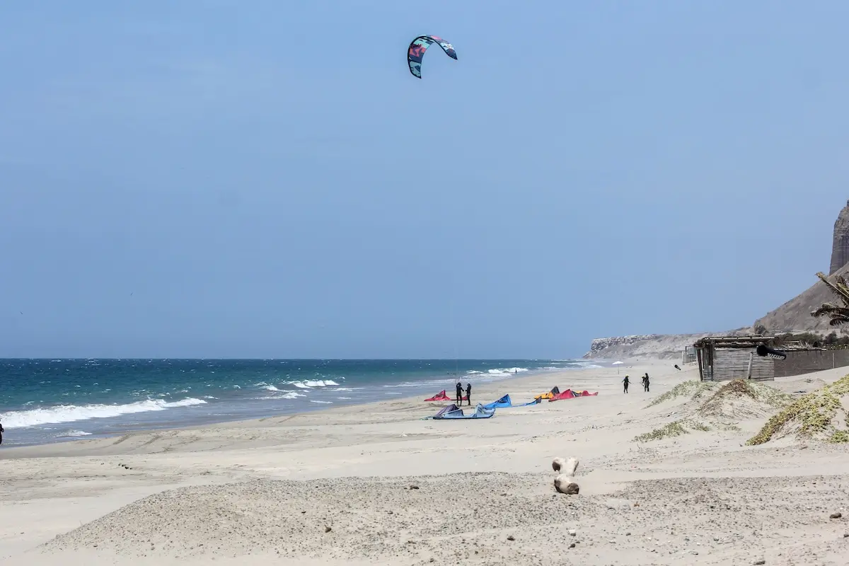 Wide sandy beach with kites and riders at the Kite Sisters women's kiteboarding camp in North Shore Peru.