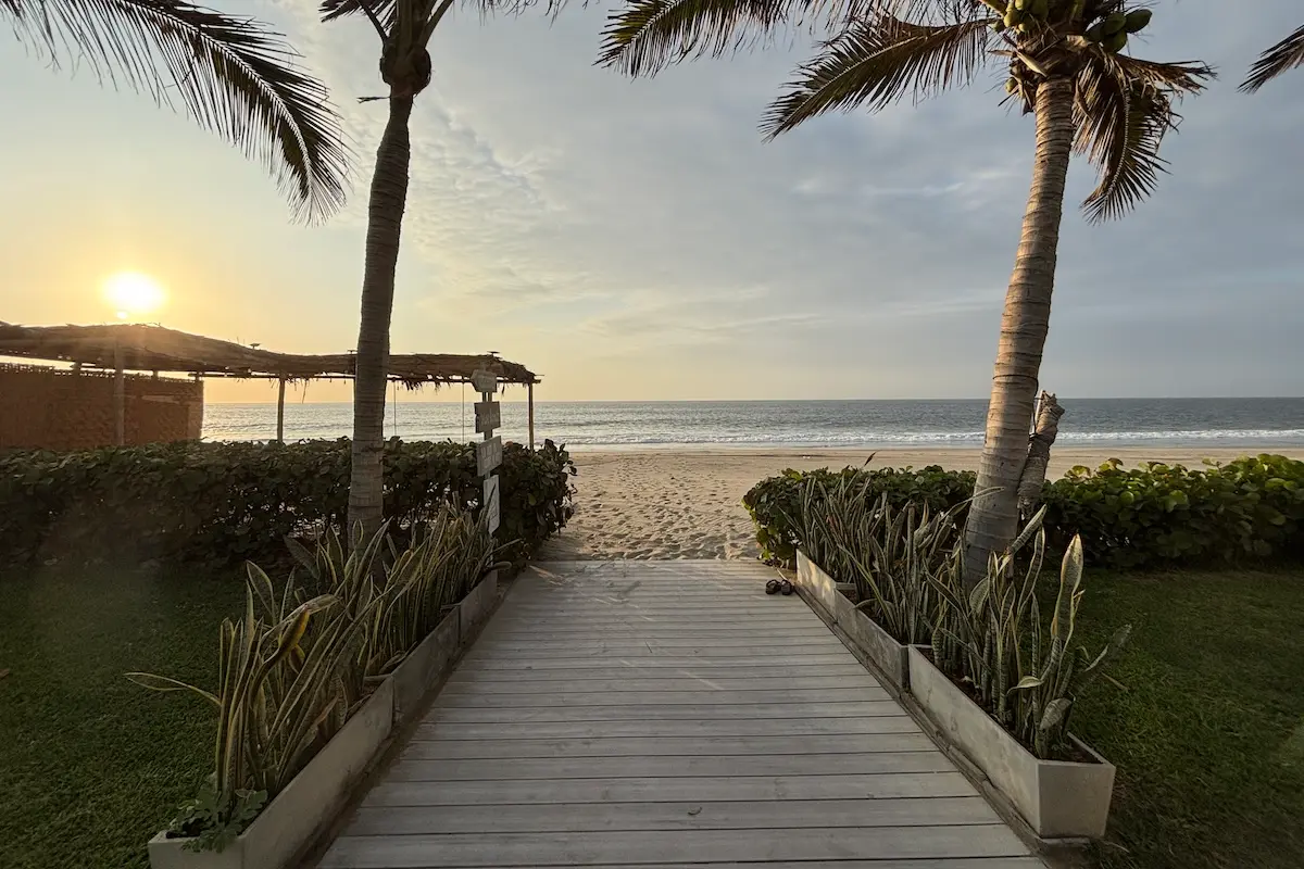 Wooden boardwalk leading to the beach at sunset at Kite Sisters women's kiteboarding camp Peru.