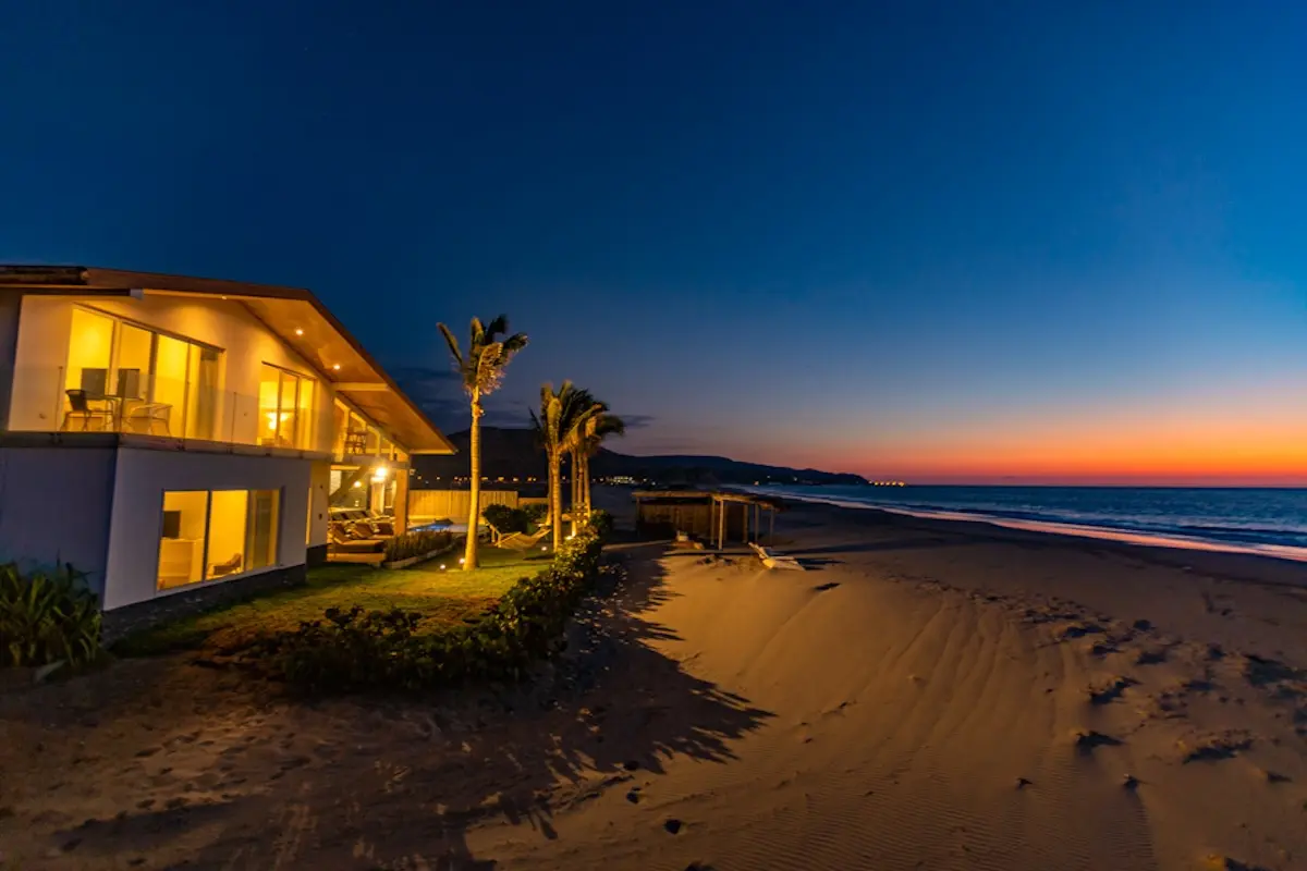 Illuminated beachfront villa at sunset at Kite Sisters women's kiteboarding camp in Peru.