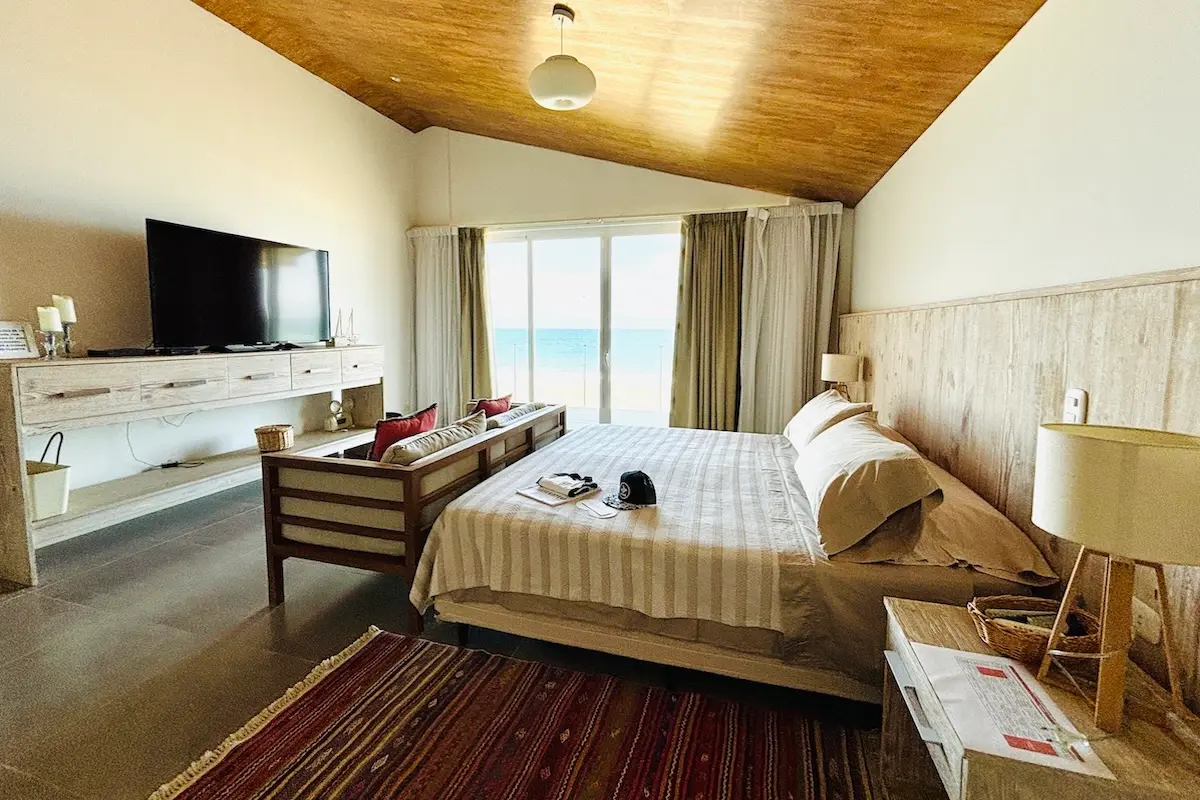 Warm and cozy beachfront bedroom with ocean view sliding doors and Kite Sisters welcome pack in Peru.