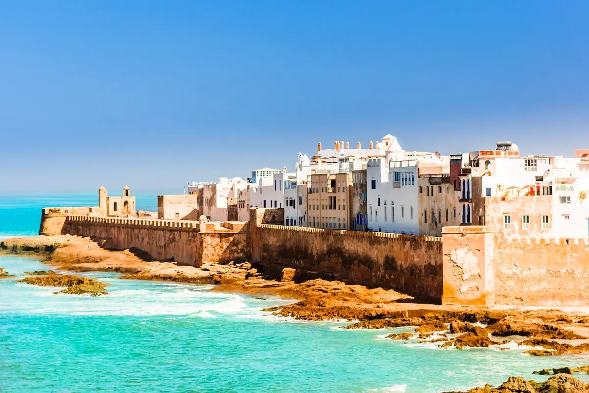 Aerial view of Essaouira's historic white medina walls and turquoise Atlantic coastline, near the Morocco kitesurf retreat location.